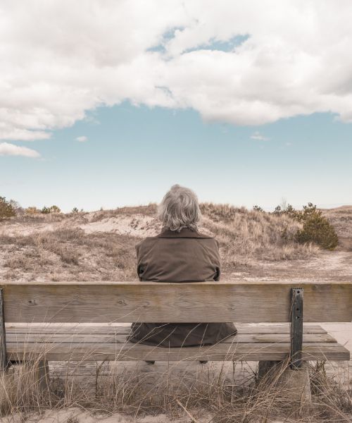 personne non binaire assis sur un banc